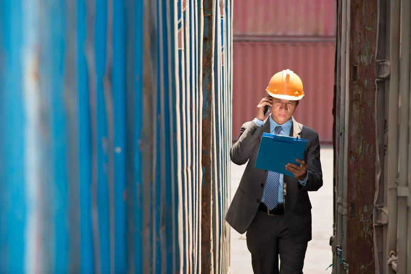 Inspector reviewing cargo at a busy port